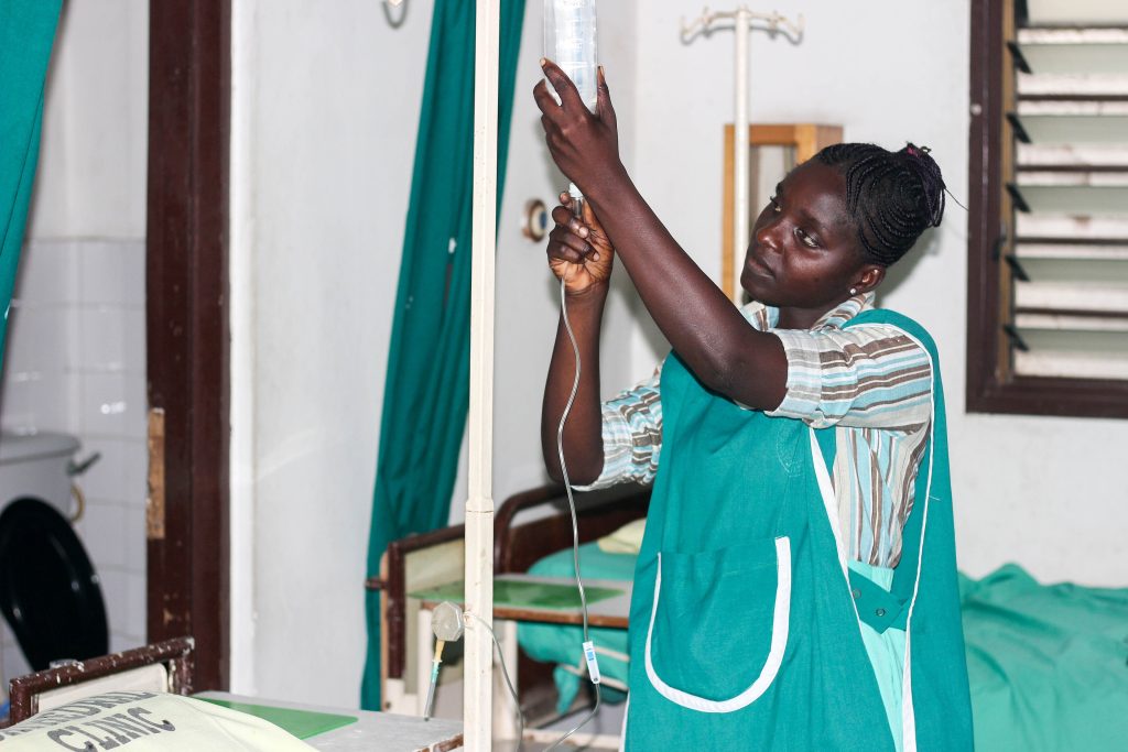 A nurse sets up an intravenous infusion on a ward at a clinic in Accra, Ghana